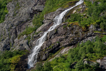 Snow is melting and make waterfall down the mountain side.