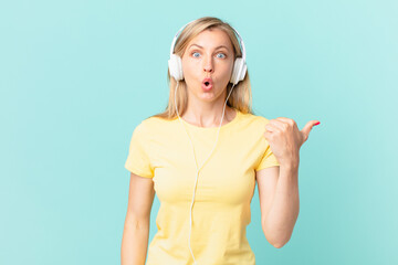 young blonde woman looking astonished in disbelief and listening music.