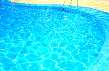 Background of blue transparent water in the swimming pool on the territory of the hotel. Rest and relaxation concept. Active rest by the sea.