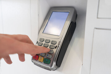 person's hand enter password and push buttons to make a payment