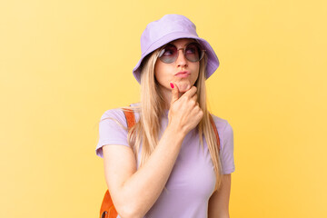 young blonde woman thinking, feeling doubtful and confused. summer concept
