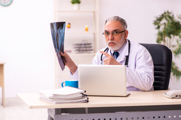 Aged male doctor radiologist working in the clinic