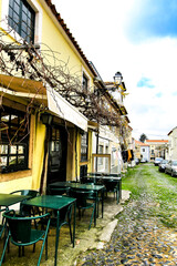 Empty bar terrace on Narrow street of Lisbon in a cloudy day