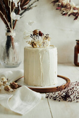 Closeup shot of delicious Boho ombre cake with dry flowers on a white table © Edgard Schmeichel/Wirestock