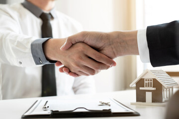 Home insurance agent shaking hand with the customer in the office.