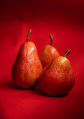 Three pears on red background