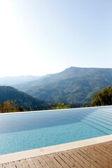 Infinity pool with panoramic mountain view. Close up, copy space for text, top view, background.