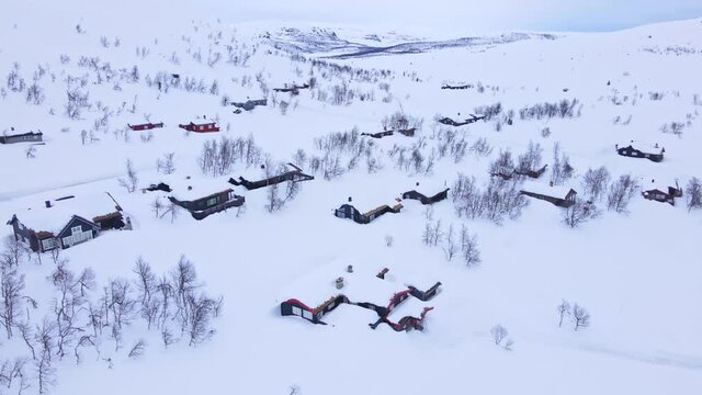 Panorama over Beitost&oslash;len village and ski resort with cozy log cabins on a cloudy winters day.
