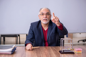 Old teacher physicist sitting in the classroom