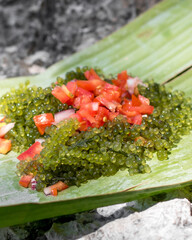 Fresh summer seaweed lato with tomatoes on a banana leaf © Alexander