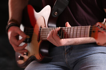 Obraz na płótnie Canvas Man playing electric guitar on stage, closeup. Rock concert