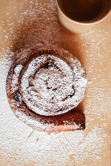 Puff pastry cakes curl with powdered sugar on top. A close-up of a bakery product. Confectionery work and customer service. A treat on a tray.