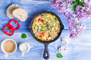 Morning egg omelette with vegetables on a wooden table