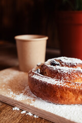 Puff pastry cakes curl with powdered sugar on top. A close-up of a bakery product. Confectionery work and customer service. A treat on a tray.