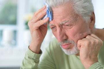 Portrait of sad sick senior man with  headache