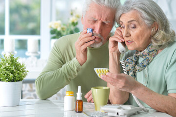 ill Senior couple with pills at home