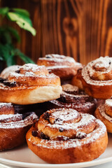 Puff pastry cakes curl with powdered sugar on top. A close-up of a bakery product. Confectionery work and customer service. A treat on a tray.