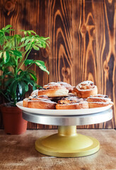 Puff pastry cakes curl with powdered sugar on top. A close-up of a bakery product. Confectionery work and customer service. A treat on a tray.