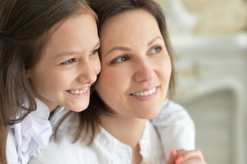 Beautiful young mother and  cute little daughter posing