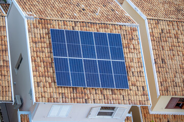 Painéis solares no telhado de uma casa. Economia de energia, meio ambiente e energia renovável. - obrazy, fototapety, plakaty