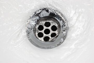 Sink plug drain hole bath plughole, white basin spout, running water macro closeup, stainless...
