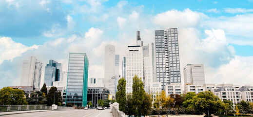 Obraz premium Panoramic Skyline Frankfurt view from the Bridge - Untermainbrücke on blue clear clouds sky. High-rise buildings in Frankfurt - Main in Germany, Hesse 