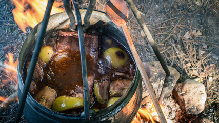 Cooking on fire in nature, boiled vegetables and meat in a boiler. Top view, camping bushcraft...