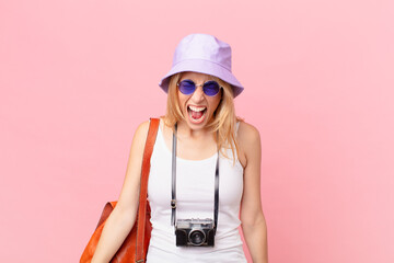 young blonde woman shouting aggressively, looking very angry. summer concept