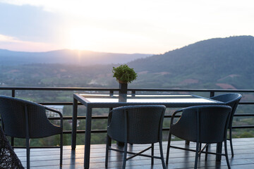 Tables and chairs in the cafe overlooking the mountain scenery. And sunset