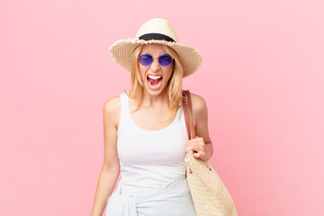 young blonde woman shouting aggressively, looking very angry. summer concept