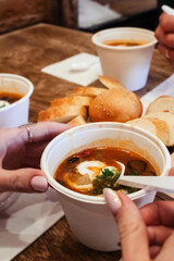 Close-up of a hodgepodge in a disposable paper cup. The concept of traditional food and foreign cuisine. Safe eco-friendly disposable tableware.