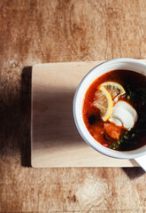 Close-up of a hodgepodge in a disposable paper cup. The concept of traditional food and foreign cuisine. Safe eco-friendly disposable tableware.