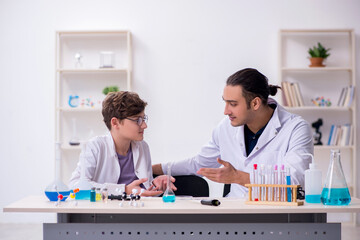 Fototapeta na wymiar Young father and son chemists in the lab