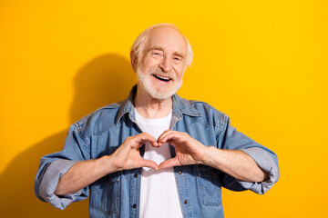 Portrait of satisfied friendly person hands fingers make show heart symbol isolated on yellow color...