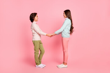 Full size profile side photo of boy and girl hold hands look at each other brother and sister...