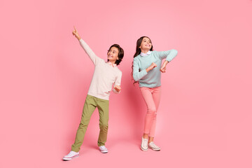 Full length body size view of beautiful cheerful kids dancing having fun rest party isolated over pink pastel color background