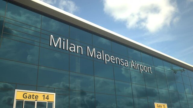 Commercial plane take off reflecting in the windows with Milan Malpensa Airport text