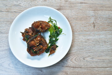 spicy stir fried crispy catfish curry with basil leaf on plate