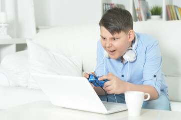 boy playing computer game with laptop