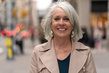 Mature caucasian woman in city smiling happy face portrait