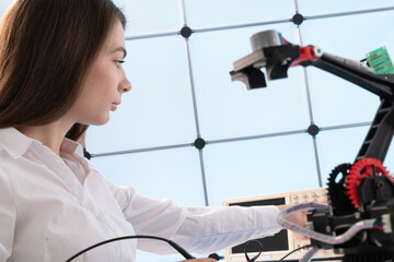 A young woman writes an algorithm for the robot arm. Science Research Laboratory for Robotic Arm...