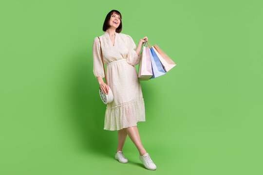 Full length body size photo woman in spring wearing glamour outfit bag keeping bags after sale isolated pastel green color background