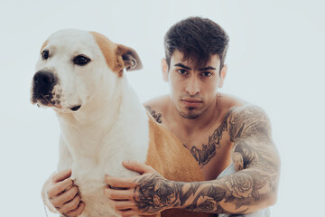 Portrait of a young man with tattoos and a dog