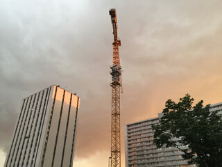 A tower crane and apartment buildings at sunset in Katowice, Poland
