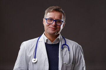 Friendly confident middle-aged male doctor in lab coat