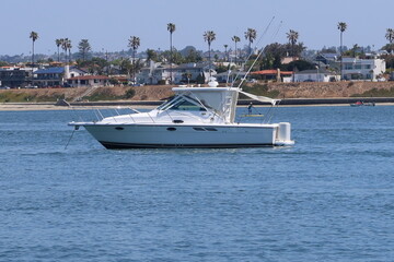 Fototapeta na wymiar Yacht on a Quiet Mission Bay, San Diego, in Southern California with Palm Trees in the Background