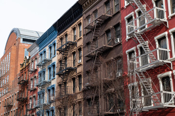 Row of Colorful Old Apartment Buildings in Greenwich Village of New York City with Fire Escapes
