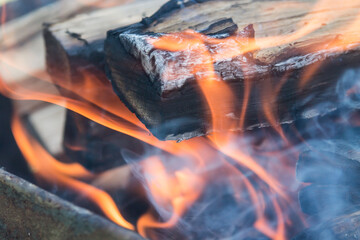 a Burning firewood in the fireplace close up, BBQ fire, charcoal background. Charcoal fire with sparks