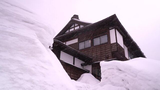 Snowed in wooden building with high snow walls surrounding it