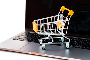 Online shopping concept. Shopping cart on the laptop. Isolated on white background.